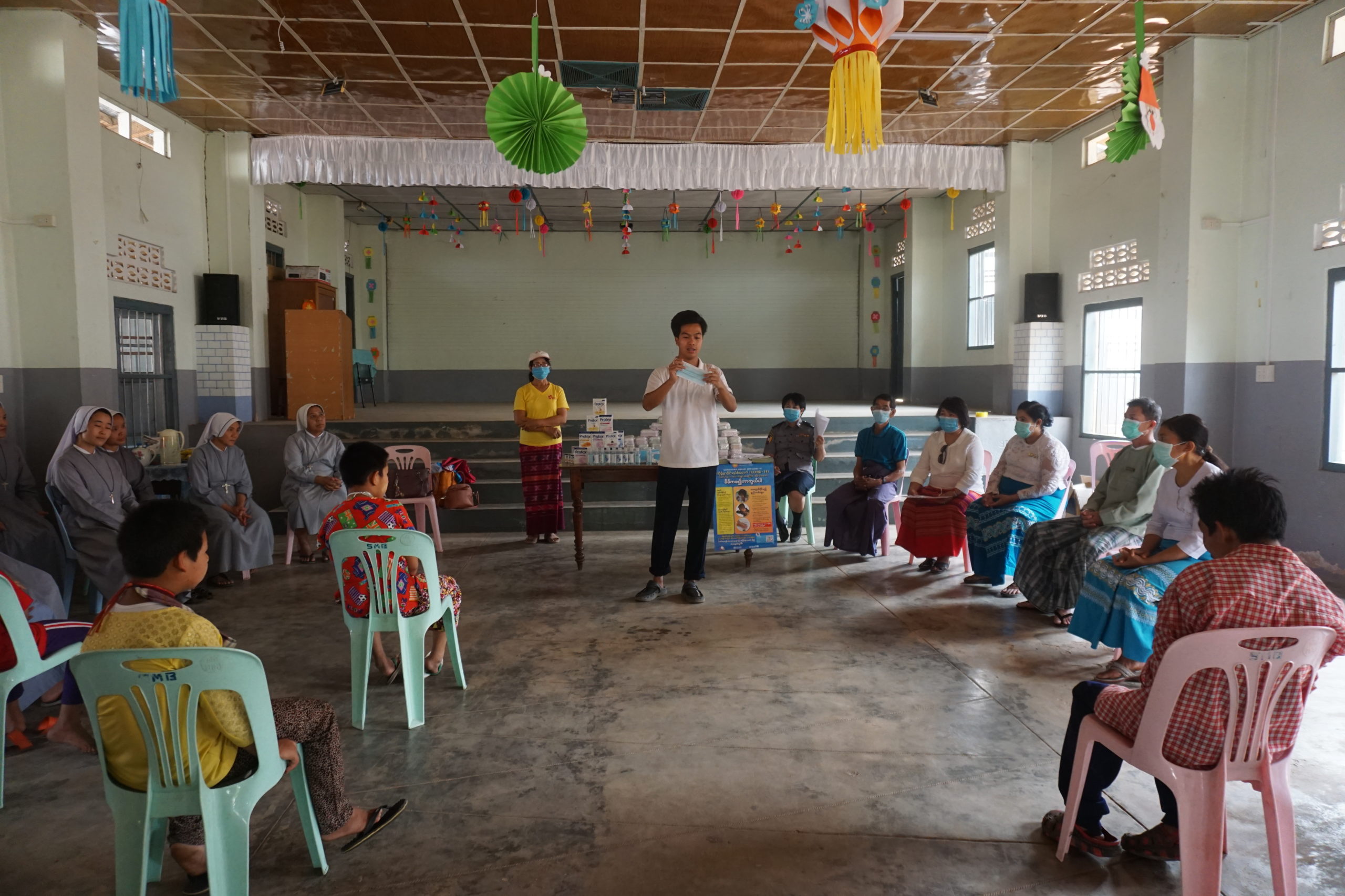 A trainer provides training to a community group on how to prevent Covid-19