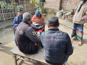 Two members of the BIGD Durdiner Diary field research team interview two men whilst a third man looks on